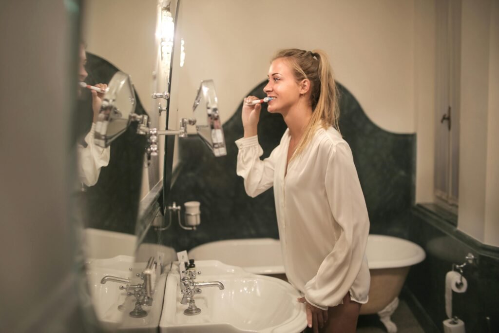 Woman brushing teeth in the morning as part of a healthy routine