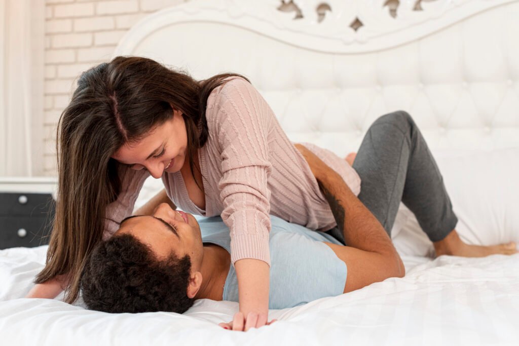 Married couple sitting on bed talking to improve emotional intimacy