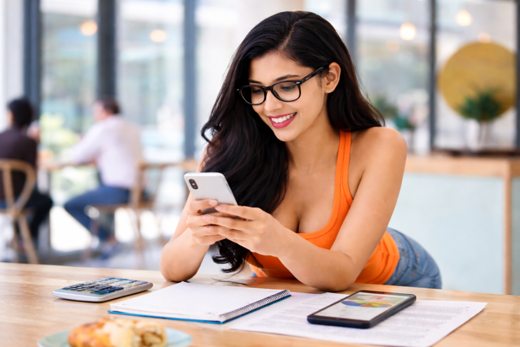 Female student in India using a budgeting app on her smartphone to track expenses