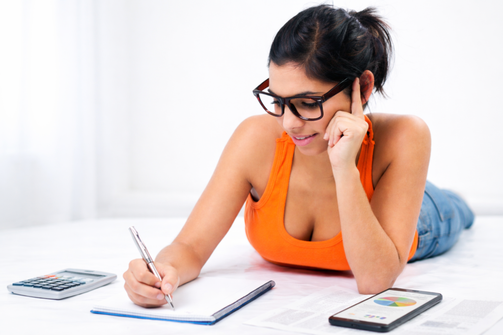 student writing budget plan and tracking expenses in notebook